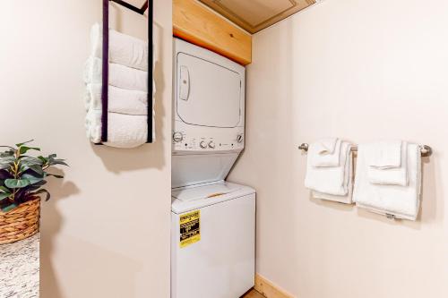a small laundry room with a refrigerator and towels at Camp Two Loons in Oxford