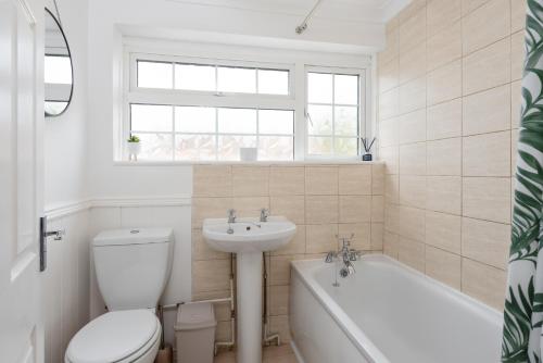 ein Badezimmer mit einem WC, einem Waschbecken und einer Badewanne in der Unterkunft Stylish & Spacious 3BR Home With Private Driveway in Bletchley