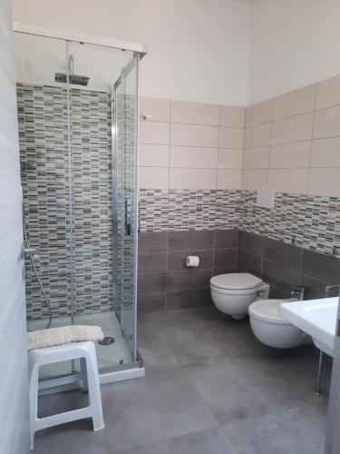 a bathroom with a shower and a toilet and a sink at CENTRAL ROOMS TORTOLI' in Tortolì