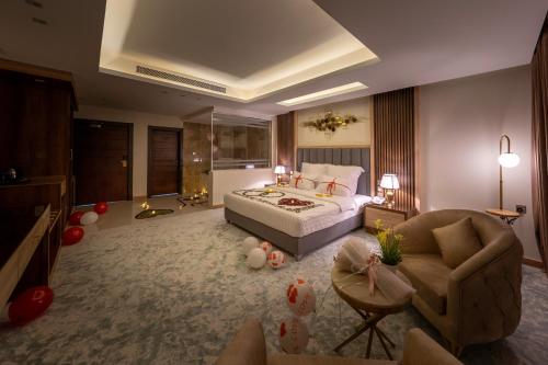 um quarto com uma cama, um sofá e uma cadeira em فندق الرؤية الجديدة em Jazan