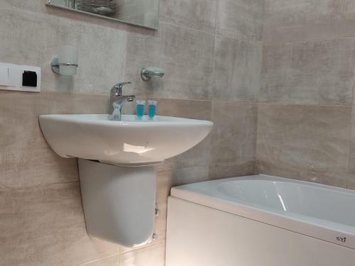 a bathroom with a sink and a bath tub at Pushkin street Pearl in Kutaisi