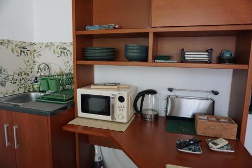 a microwave sitting on a counter in a kitchen at Chez Louise: onde a Serra beija o Céu in Lousã