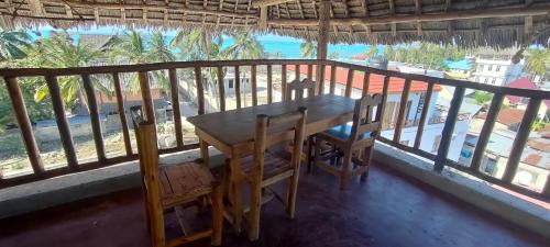 a table and chairs on a balcony with a view of the ocean at Mambo Boutique Nungwi in Nungwi