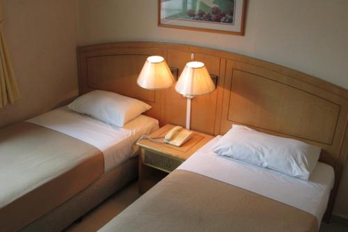 Tempat tidur dalam kamar di New Orchid Hotel