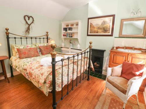 a bedroom with a bed and a fireplace at Clematis Cottage in Bakewell