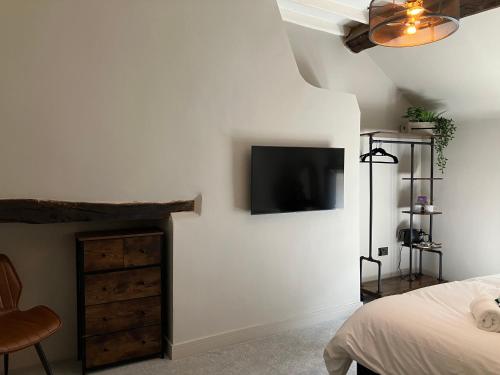 ein Schlafzimmer mit einem Bett und einem Fernseher an der Wand in der Unterkunft Lawton Street Rooms in Congleton