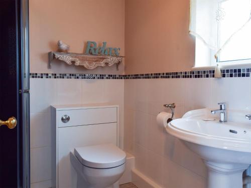 a bathroom with a toilet and a sink at Parsnip Place - Uk32606 in Manton