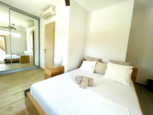a bedroom with a large white bed with a mirror at Syllas Grand Resort - Executive View Villa 1 in Edipsos