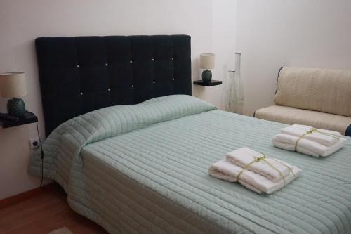 um quarto com uma cama com duas toalhas em Chez Louise: onde a Serra beija o Céu em Lousã
