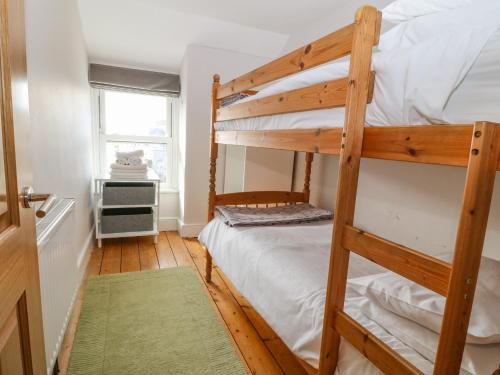 a bedroom with two bunk beds and a window at Y Castell Apartment 3 in Porthmadog