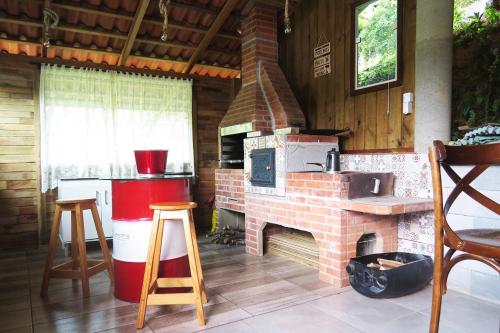 a kitchen with a brick fireplace in a cabin at Nossacasa-de-campo in Blumenau