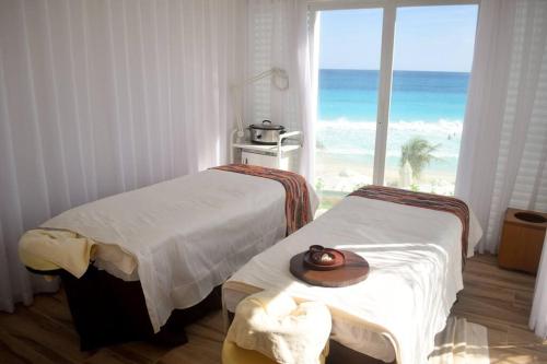 two beds in a room with a view of the ocean at Frente al mar, increíble vista, nuevo estudio 1 C in Cancún