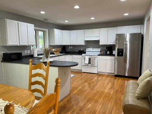 a kitchen with white cabinets and a wooden floor at Comfy Loft Beacon NY in Beacon