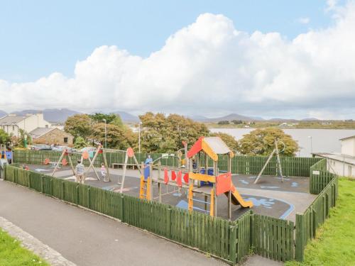 a playground in a park next to a body of water at Sea Watch House in Roundstone