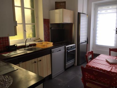 une cuisine avec un évier et une cuisinière four supérieur dans l'établissement La Residence rdc, à Le Mont-Dore