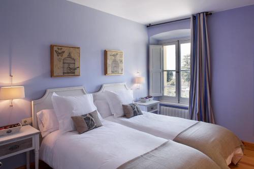 1 dormitorio con 2 camas blancas y ventana en CASONA QUINTA HERMINIA, en Gijón