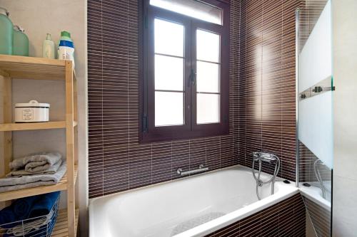Un baño con bañera y ventana. en Dúplex en el centro de Jerez, en Jerez de la Frontera
