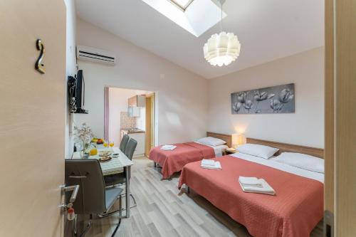een hotelkamer met 2 bedden en een bureau bij Argyruntum Apartments in Starigrad-Paklenica