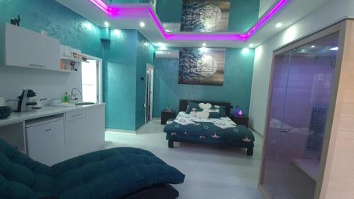 a room with a bed and a kitchen with purple lights at Apartman Melody in Paraćin
