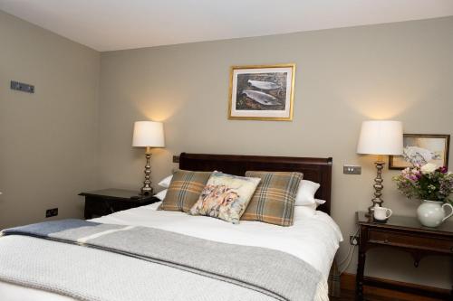 a bedroom with a bed with two night stands and two lamps at D'Arcy Spice, The Apple Rooms in Stockbridge