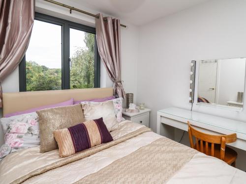 a bedroom with a bed with a desk and a window at Trevonnen in Brecon