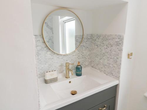 a bathroom with a sink and a mirror at Shileen in Seahouses