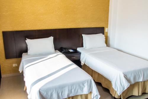 two beds sitting next to each other in a room at HOTEl TANGARA in Pereira