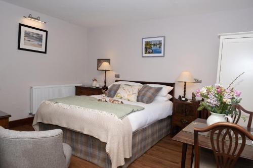 a bedroom with a bed and a table and chairs at Arthur Turner, The Apple Rooms in Stockbridge
