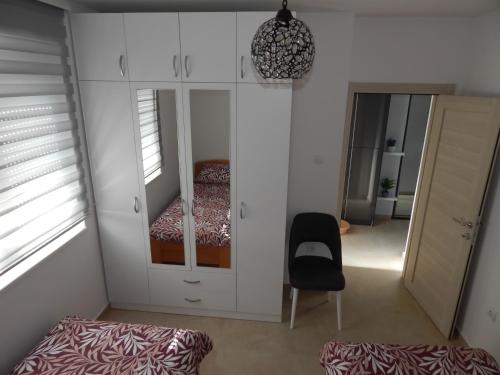 Zimmer mit einem Schlafzimmer mit einem Bett und einem Stuhl in der Unterkunft Apartman Zvezda vodilja in Veternik