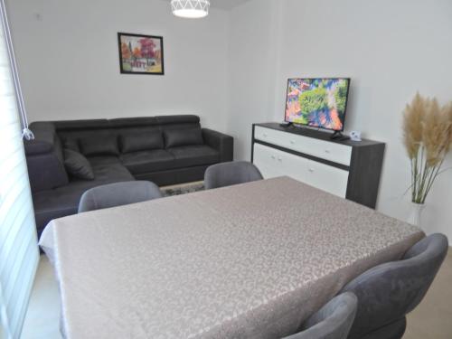 Zimmer mit einem Tisch, Stühlen und einem Sofa in der Unterkunft Apartman Zvezda vodilja in Veternik