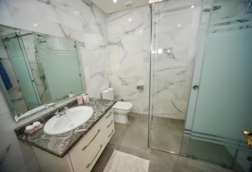 a bathroom with a shower and a sink and a toilet at Marina Agadir Family Sunny Holiday in Agadir