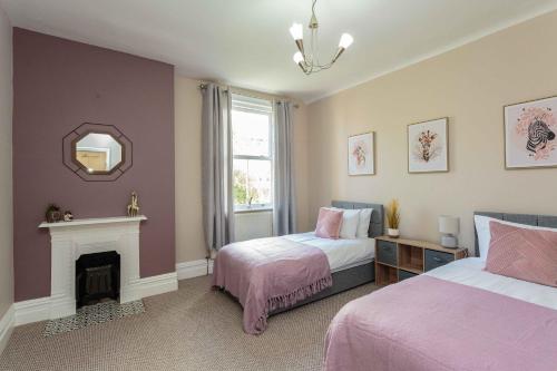 um quarto com 2 camas, uma lareira e um espelho em Orchard Lodge em Lytham St Annes