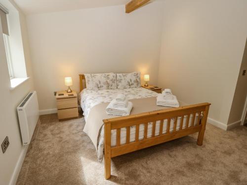 a bedroom with a bed with two towels on it at 3 Barn Cottages in Halifax