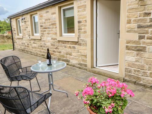 a bottle of wine sitting on a table on a patio at 3 Barn Cottages in Halifax