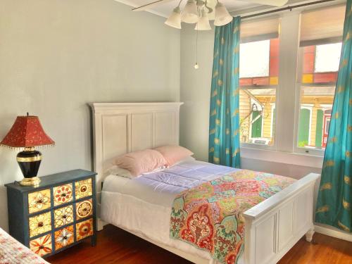 1 dormitorio con cama, lámpara y ventana en Madame Isabelle's House en Nueva Orleans