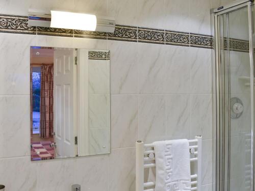 a bathroom with a mirror and a white towel at Woodside Cottage in Troutbeck Bridge