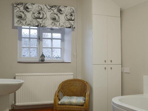 a bathroom with a sink and a toilet and a window at Ivy Cottage in South Wingfield