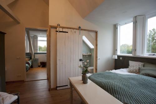 1 dormitorio con 1 cama y puerta corredera en Boutique B&B Villa Heidetuin en Bergen op Zoom