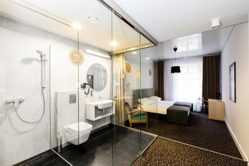 een badkamer met een douche, een toilet en een wastafel bij Sleep in Hostel & Apartments Stary Rynek in Poznań