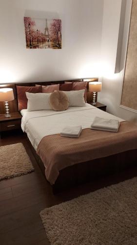 a bedroom with a large bed with two lamps at Ambiennt in Bucharest