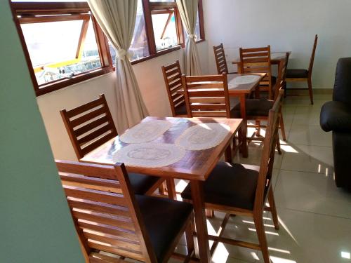 ein Esszimmer mit Tischen, Stühlen und Fenstern in der Unterkunft RESIDENCIAL AFRICA,LDA-NAMPULA in Nampula