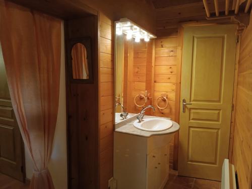 La salle de bains est pourvue d'un lavabo, d'un miroir et d'une porte. dans l'établissement GITE DE KATE, à Albières