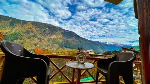 a view from a balcony with two chairs and a table at YOLO Backpackers MAX - Manali in Manāli