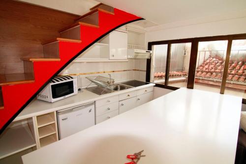 a kitchen with white counters and a red wall at Aparsol Apartments in Madrid