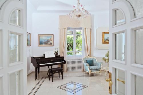 a living room with a piano and a chair at Hotel Villa Garden in Sant'Agnello