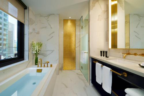 Hard Rock Hotel New York في نيويورك: حمام مع حوض ومغسلة ودش