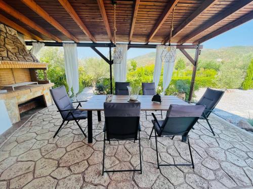 een patio met een tafel en stoelen en een piano bij Syllas Grand Resort - Prestigious Villa 8 in Edipsos