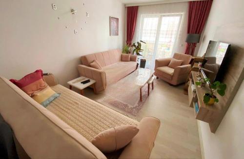 a living room with a couch and a living room with a couch at 1-Bedroom Apartment Fushë Kosovë in Kosovo Polje