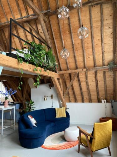 a living room with a blue couch and wooden ceilings at Number 9 holiday apartments in Middelburg