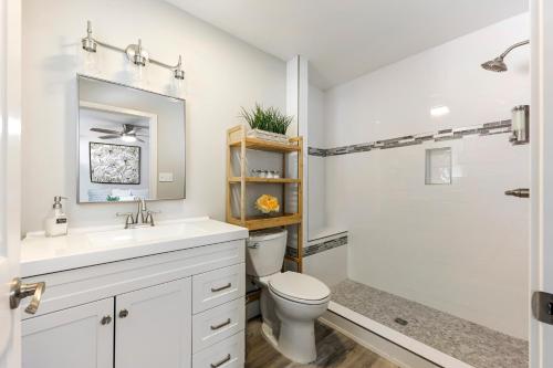 a white bathroom with a toilet and a shower at Fully Renovated 4 Bedroom Home with Pool! in Roseville